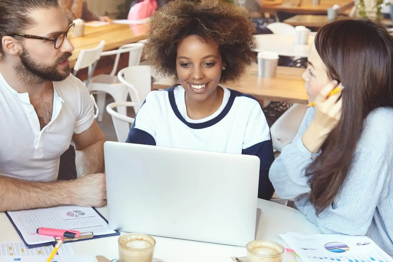 Equipo de jóvenes colegas en una reunión en una cafetería.